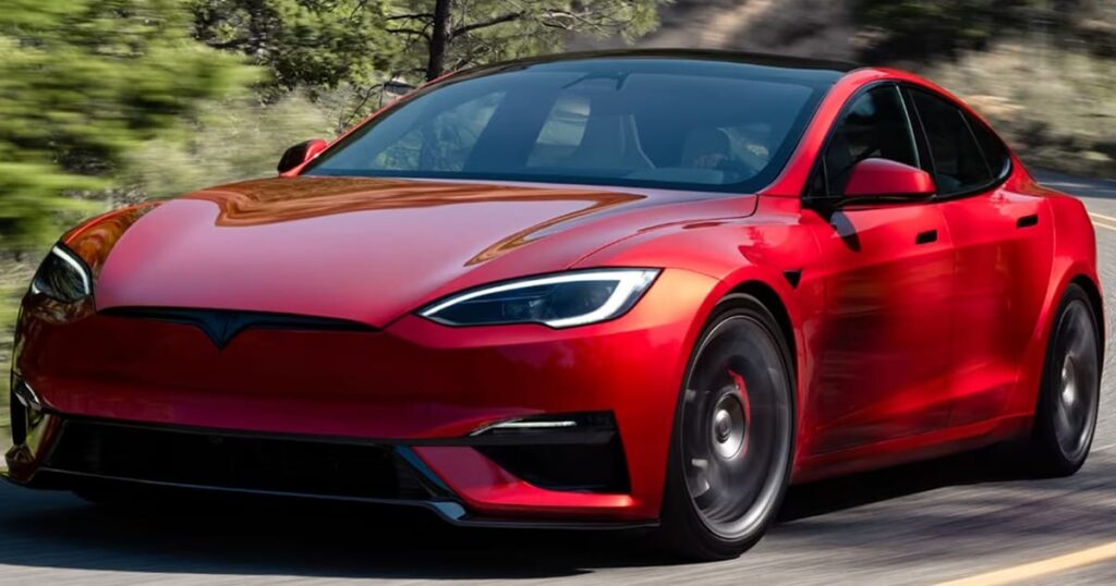 A red tesla parked under shady trees