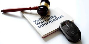 A gravel on top of a vehicle warrenty information pamphlet next to a remote car starter